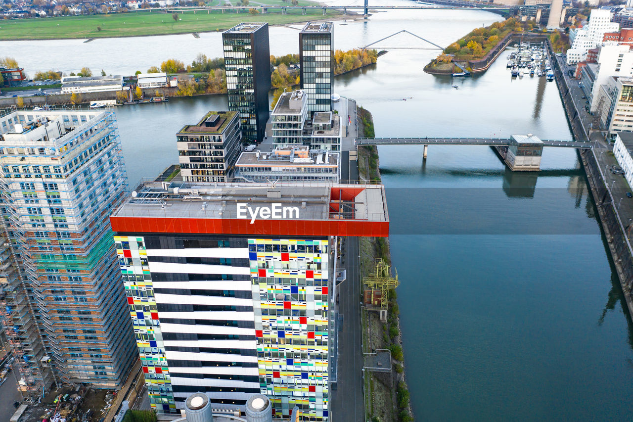 HIGH ANGLE VIEW OF PIER ON RIVER AMIDST BUILDINGS