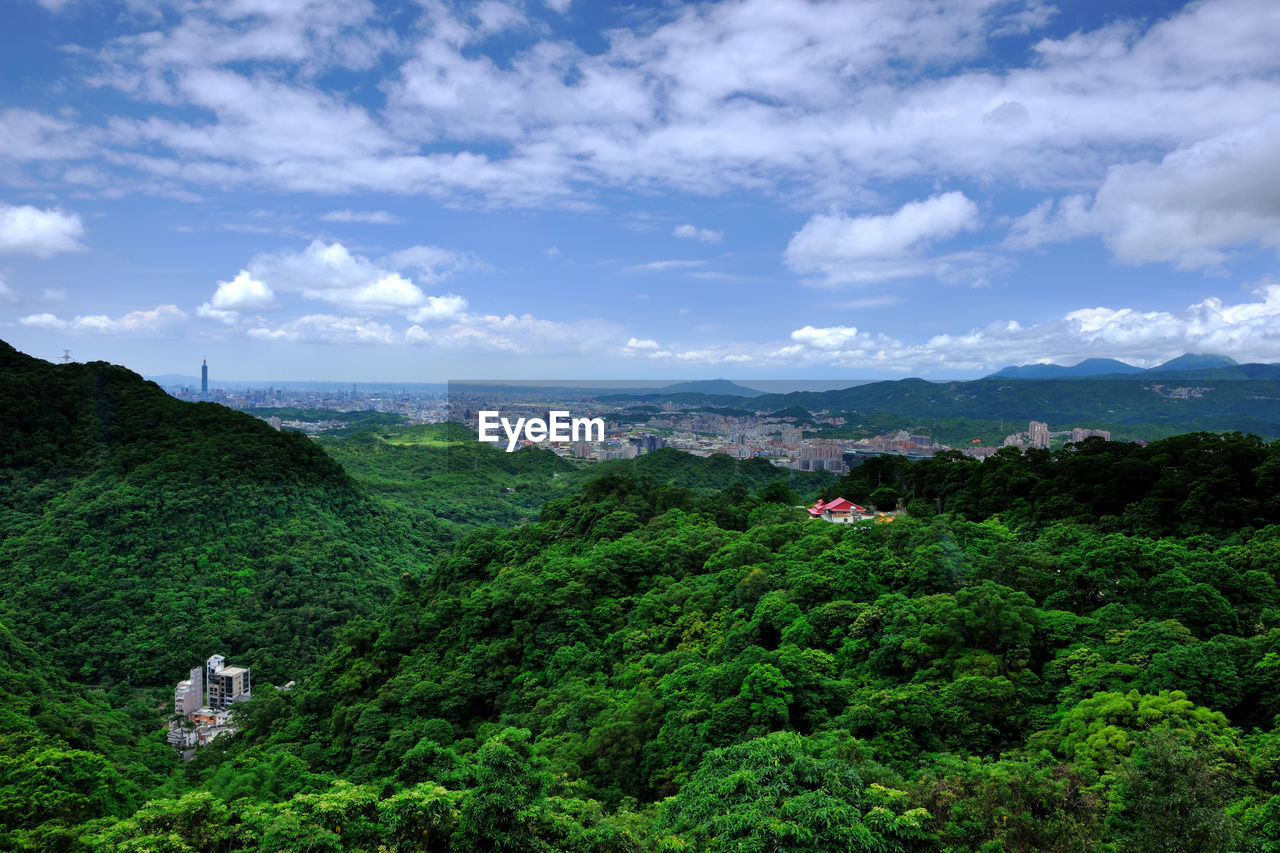 Scenic view of trees and buildings against sky