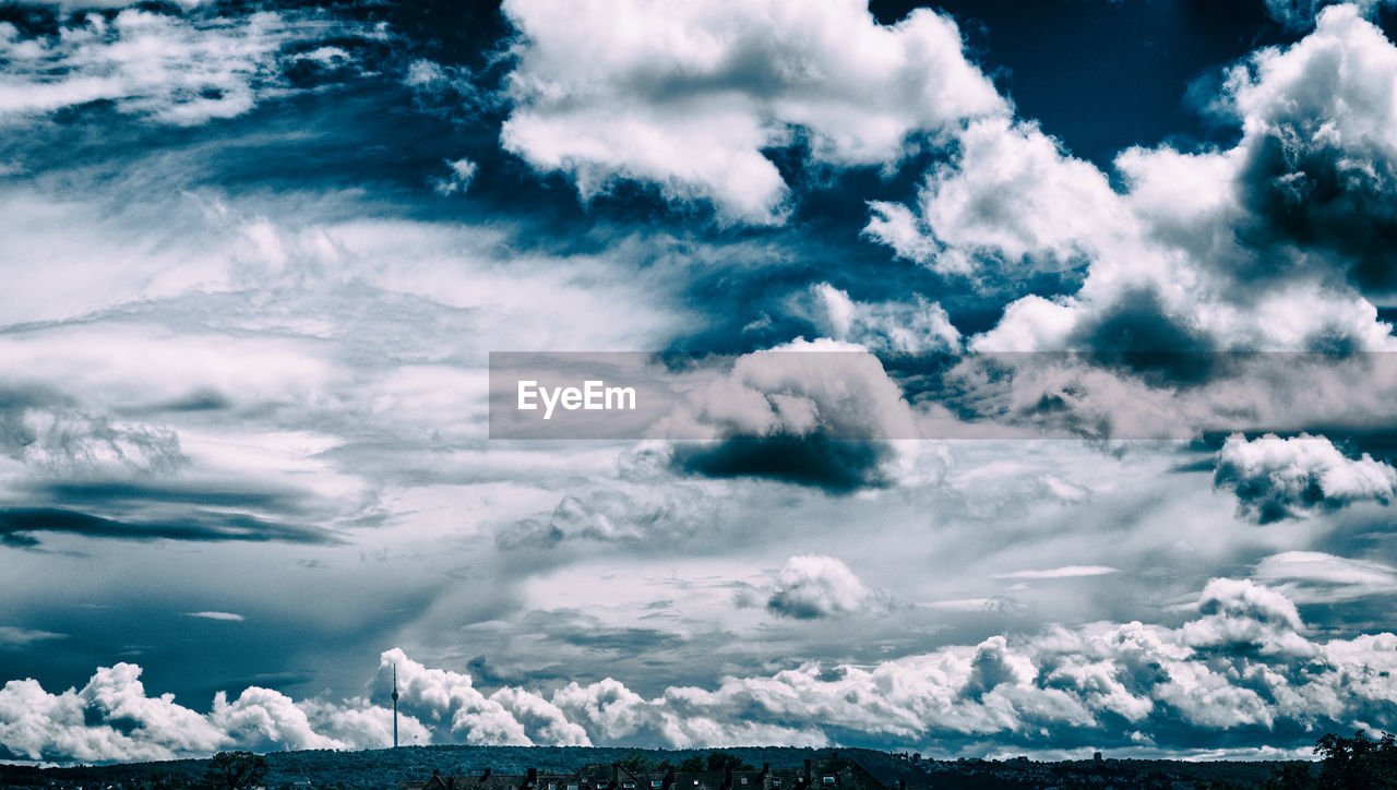 Snow covered landscape against cloudy sky