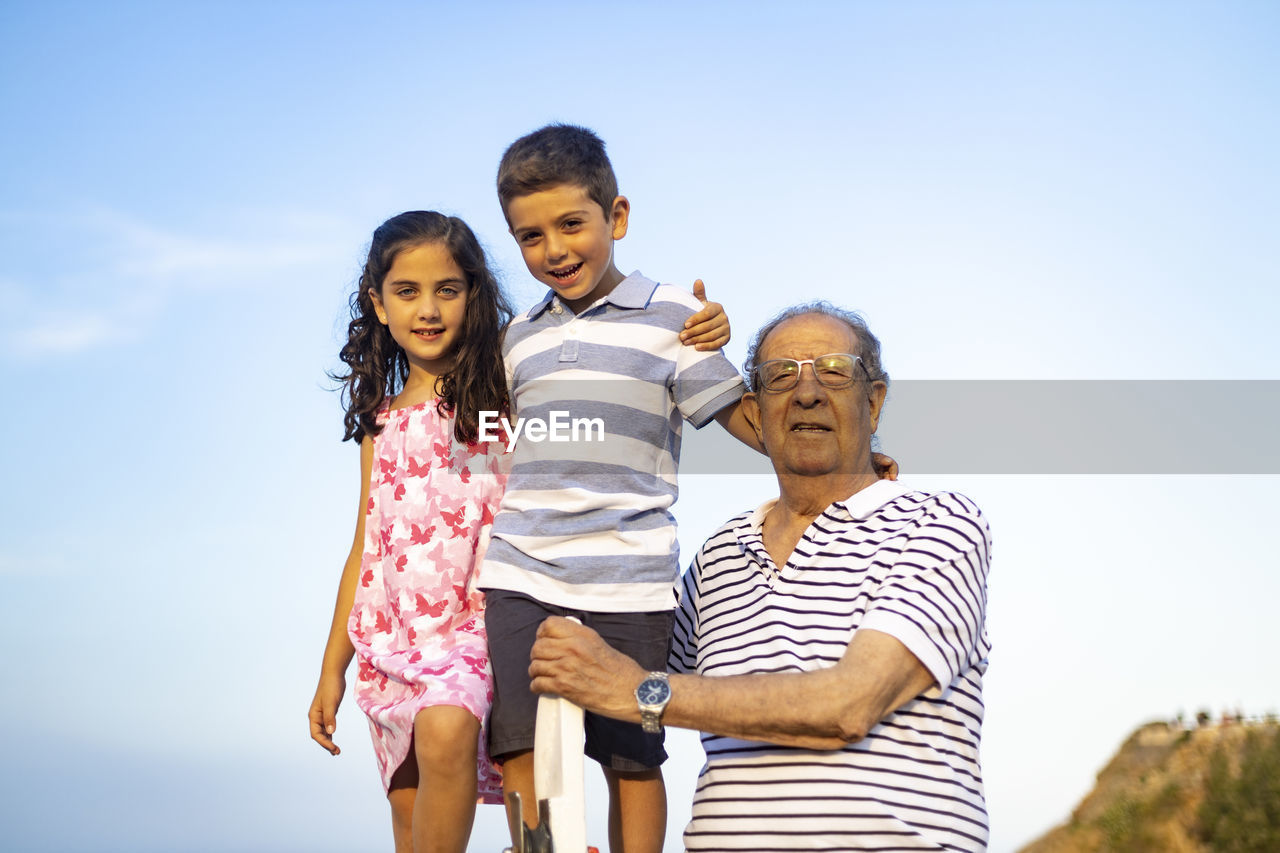Low angle portrait of family against sky