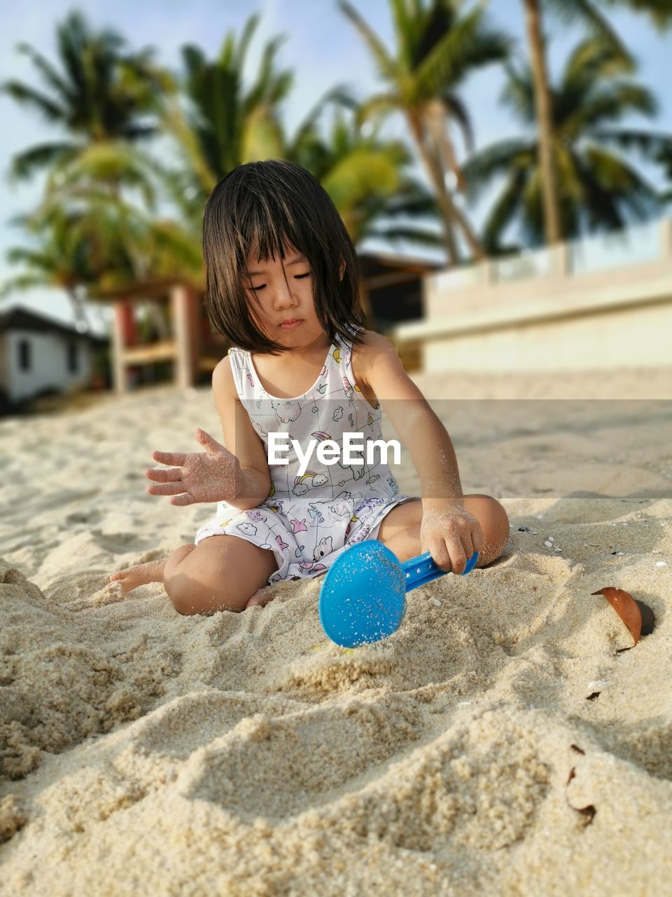 Full length of girl playing with sand at beach