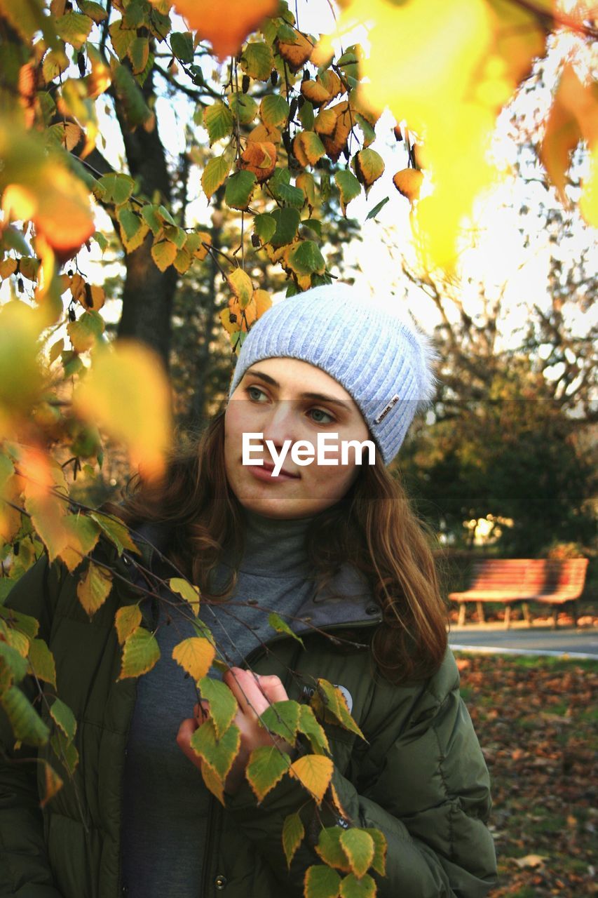 PORTRAIT OF WOMAN IN AUTUMN LEAVES