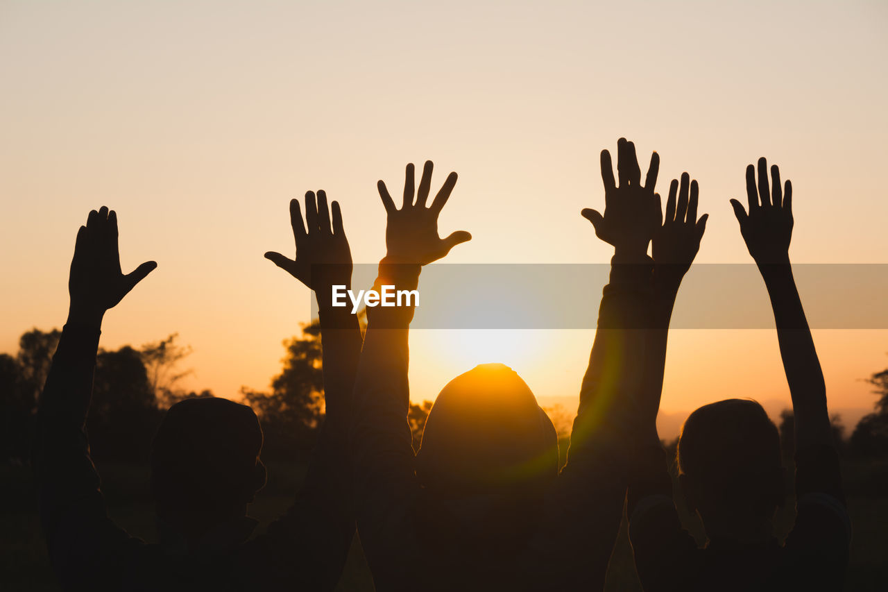 SILHOUETTE PEOPLE AT MUSIC FESTIVAL DURING SUNSET