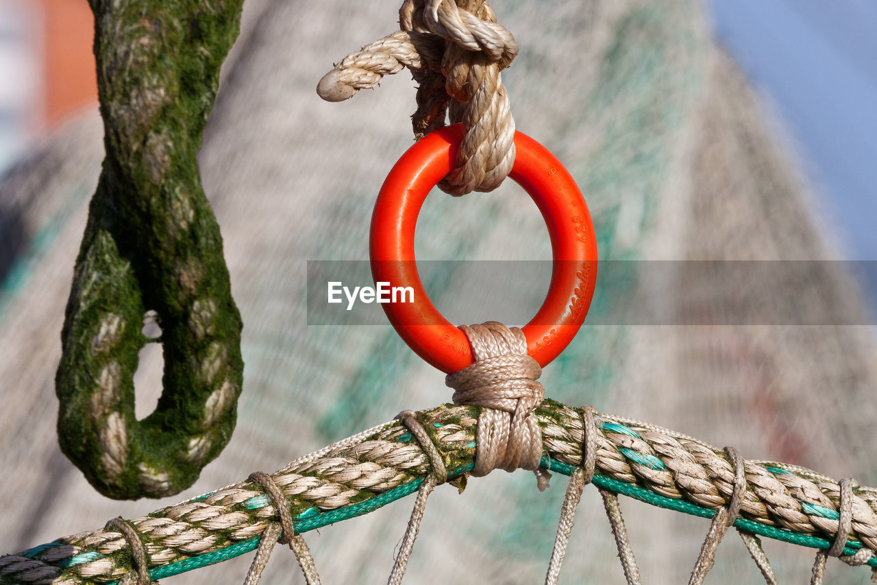 CLOSE-UP OF ROPE TIED ON METAL