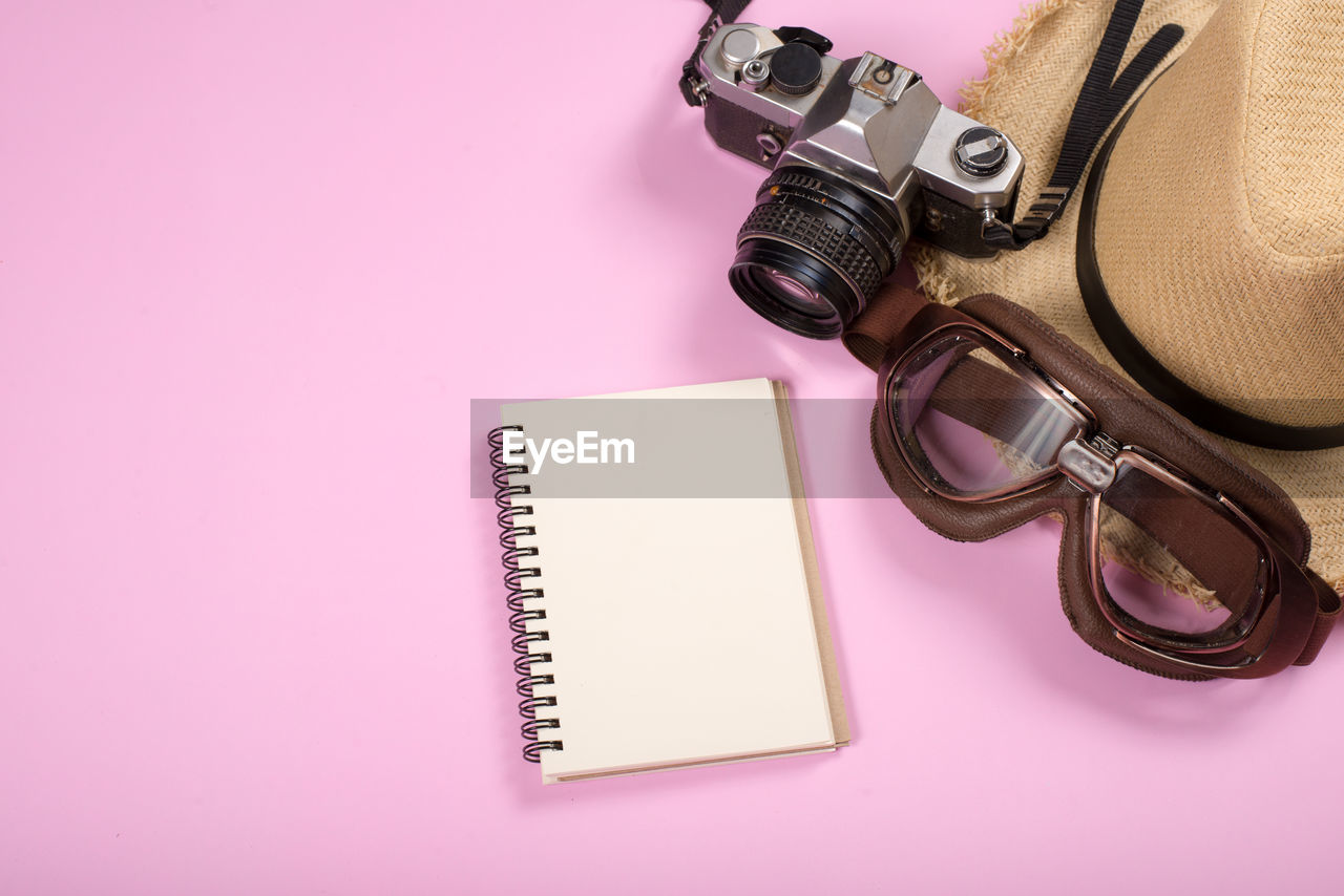 HIGH ANGLE VIEW OF CAMERA ON BOOK