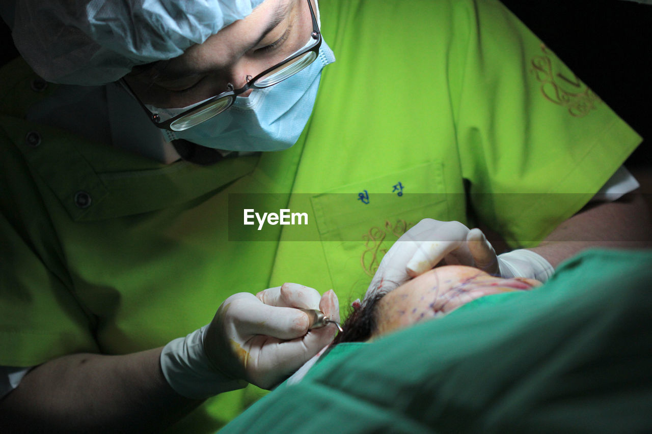 Doctor performing surgery on patient at operating room