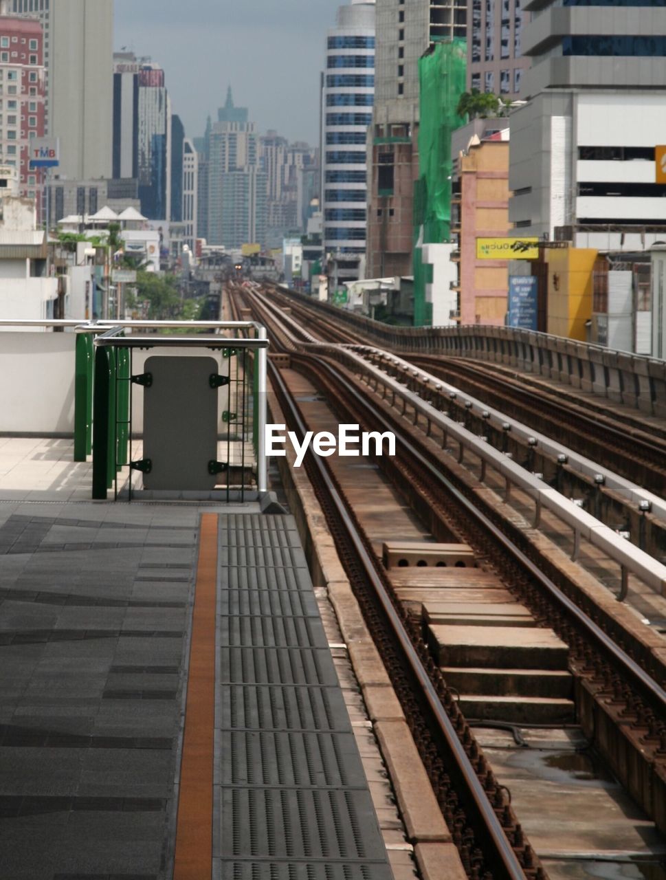 Railroad station platform against buildings in city