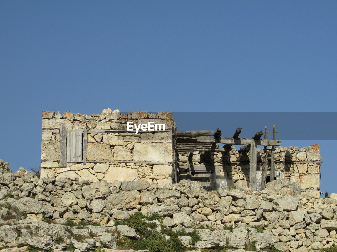 Low angle view of old building against clear blue sky