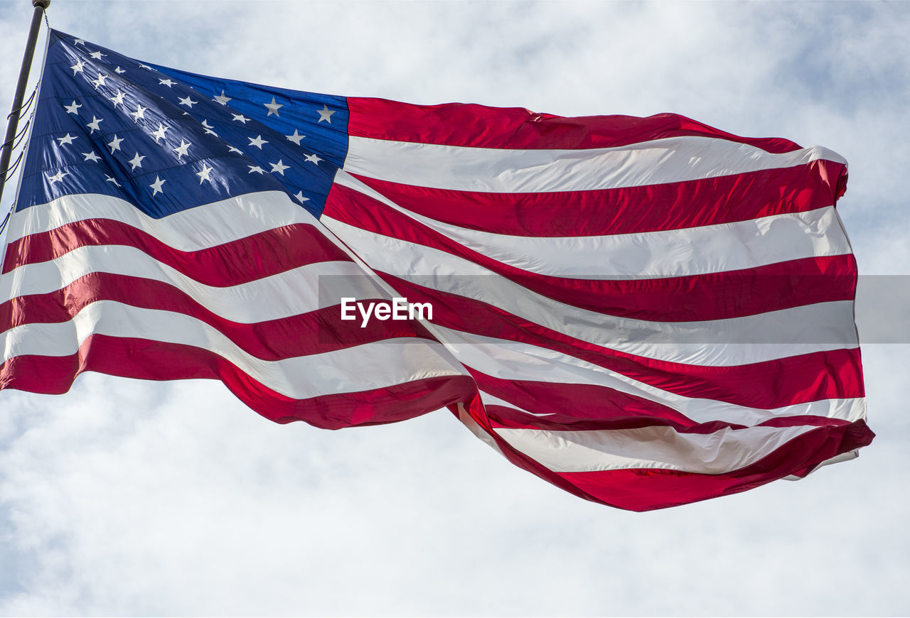 Low angle view of american flag against sky