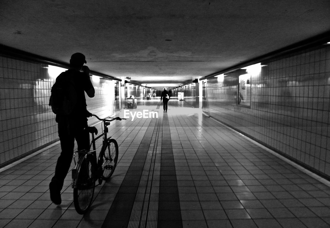 Man with bicycle walking in basement