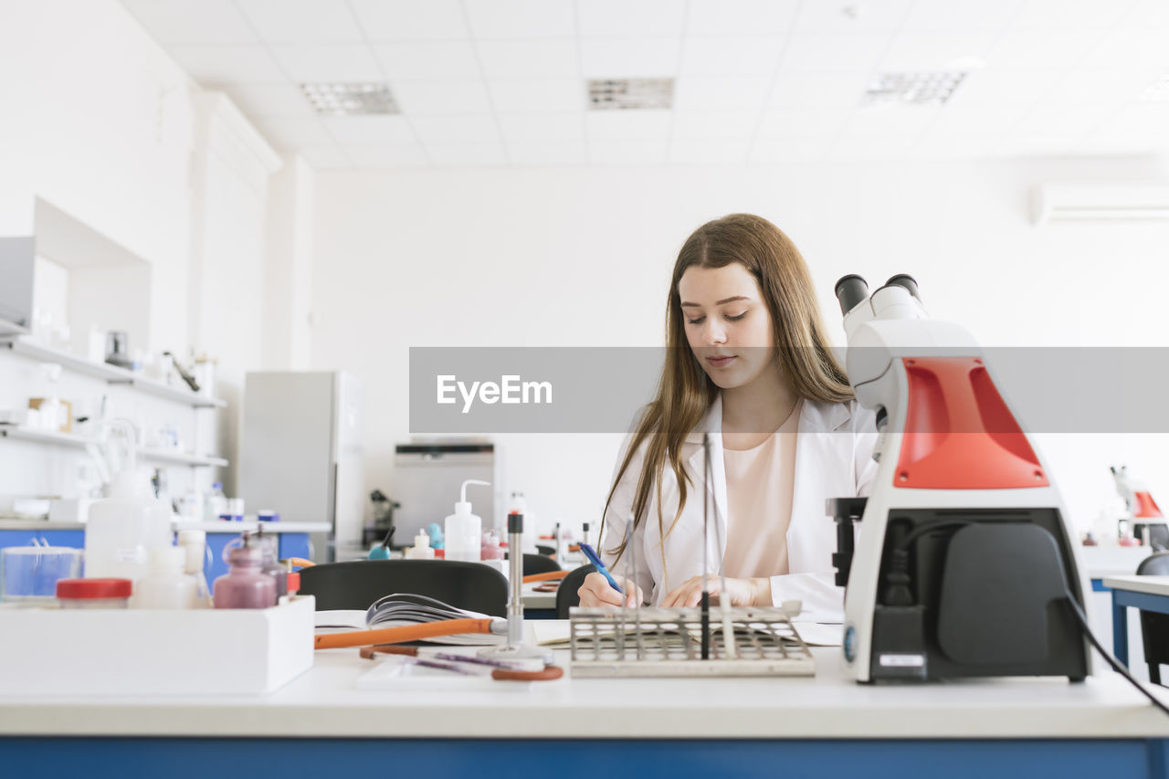 Young researcher in white coat working in a lab