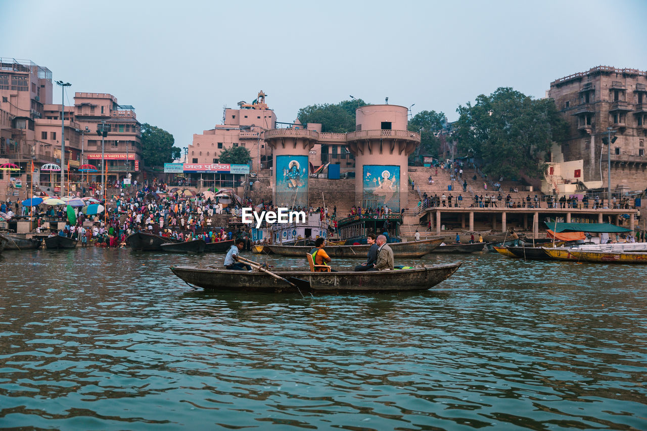 BOATS IN RIVER ALONG BUILDINGS