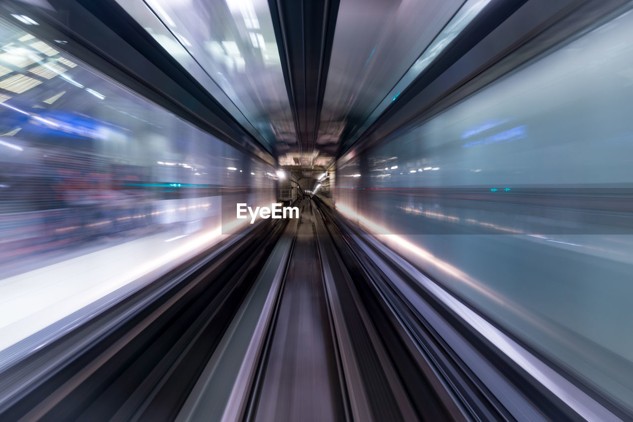Blurred motion of train at illuminated railroad station