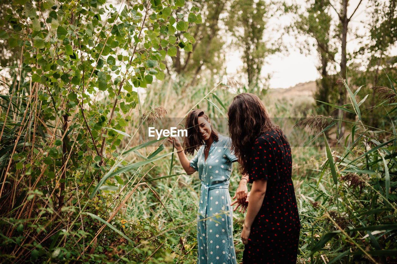 Women standing by plants in forest