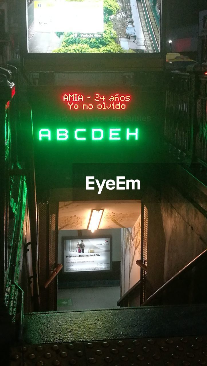 INFORMATION SIGN ON ILLUMINATED RAILROAD STATION PLATFORM