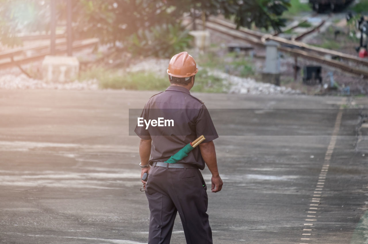 Rear view of man walking at railroad station platform