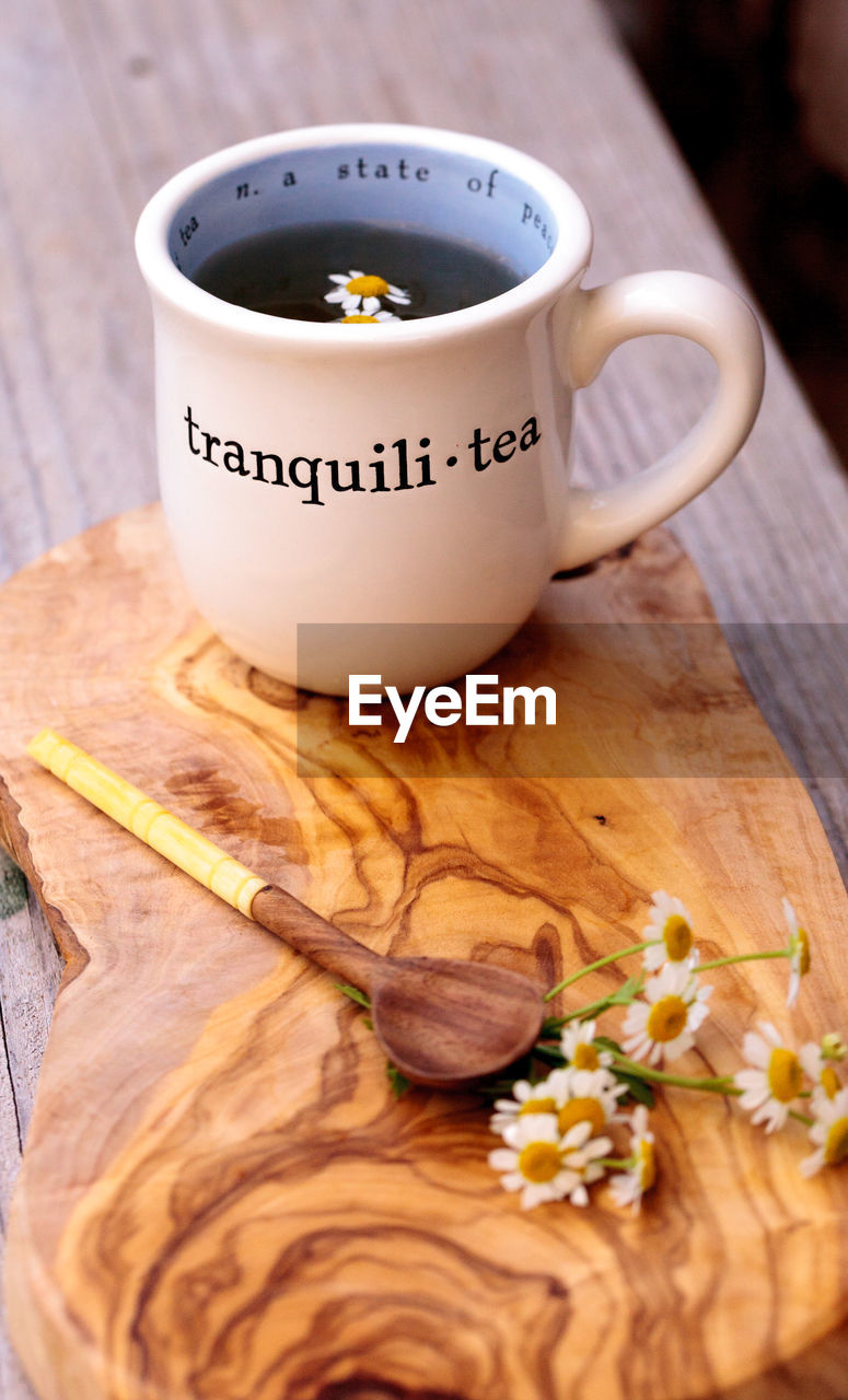 CLOSE-UP OF COFFEE CUP ON TABLE IN AUTUMN