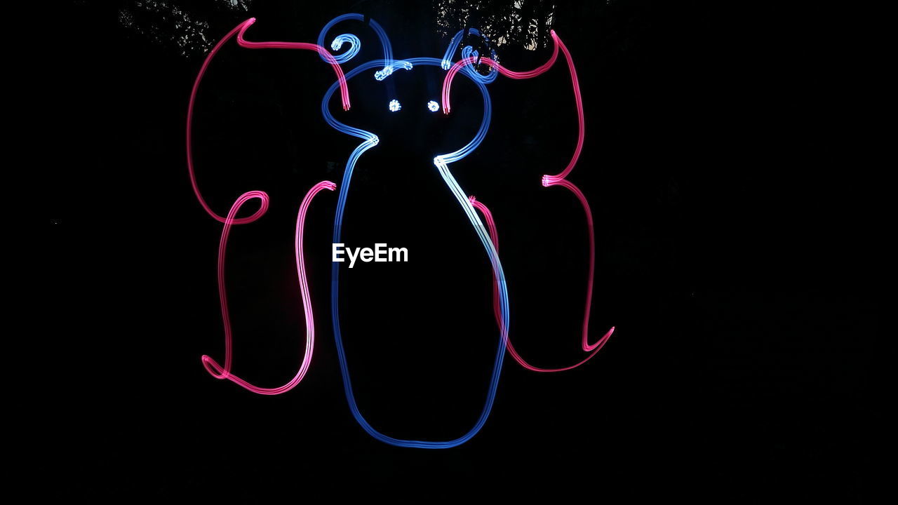 LIGHT PAINTING AGAINST BLACK BACKGROUND AGAINST SILHOUETTE OF STAR