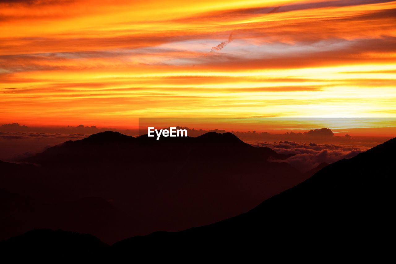 SCENIC VIEW OF SILHOUETTE MOUNTAINS AGAINST ROMANTIC SKY