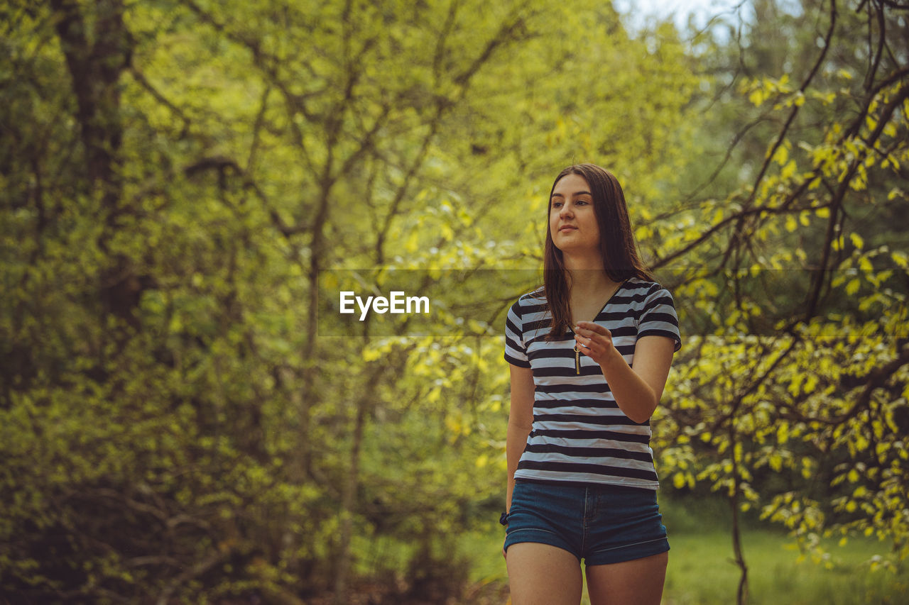 Young woman standing in forest