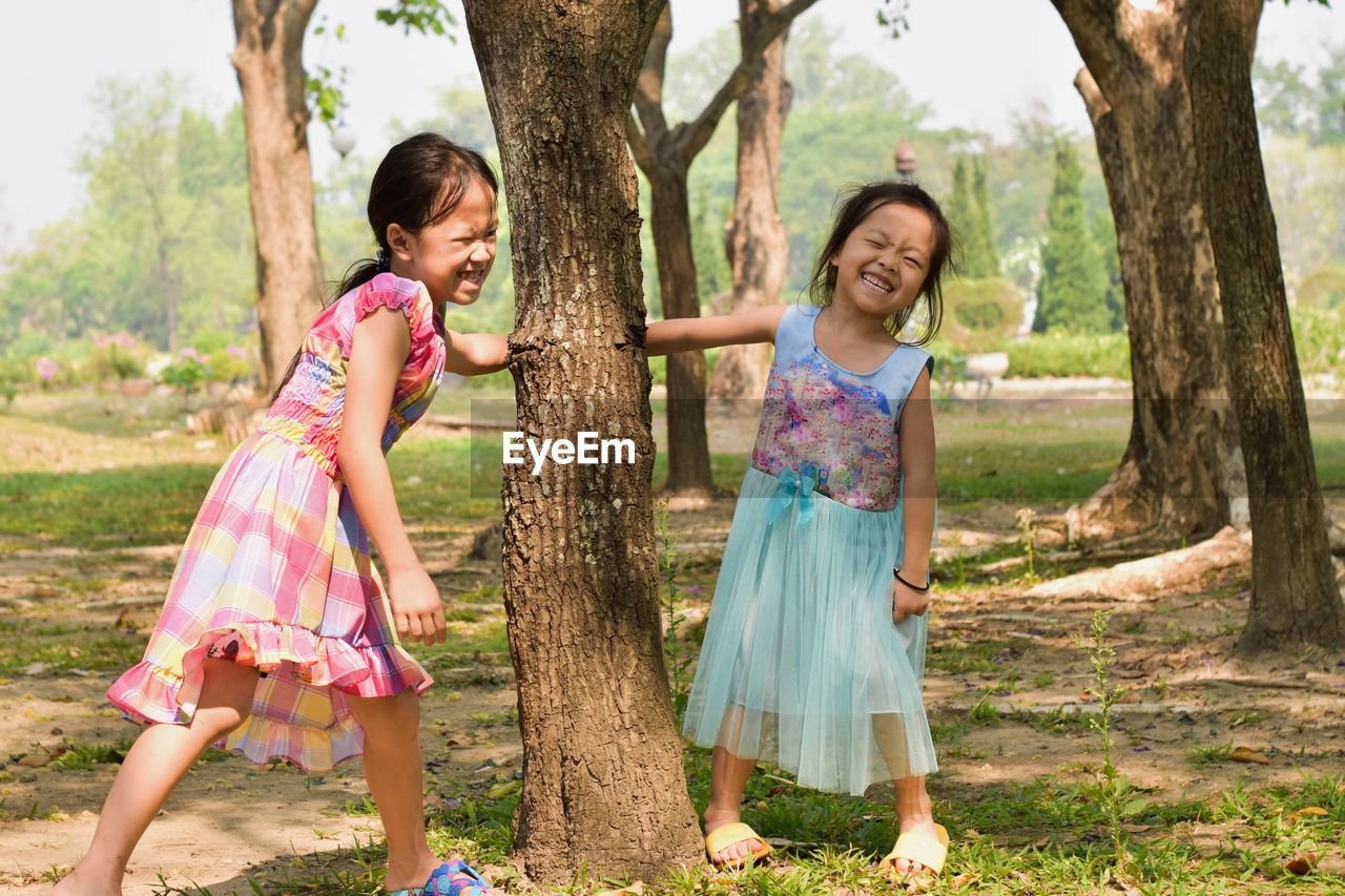 Little girl and his sister play in summer park. children with colorful clothes outdoor fun.