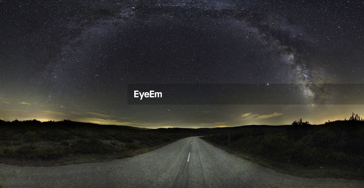 Road amidst landscape against sky at night