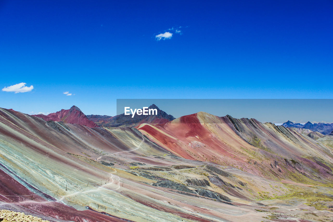 Scenic view of mountains against blue sky