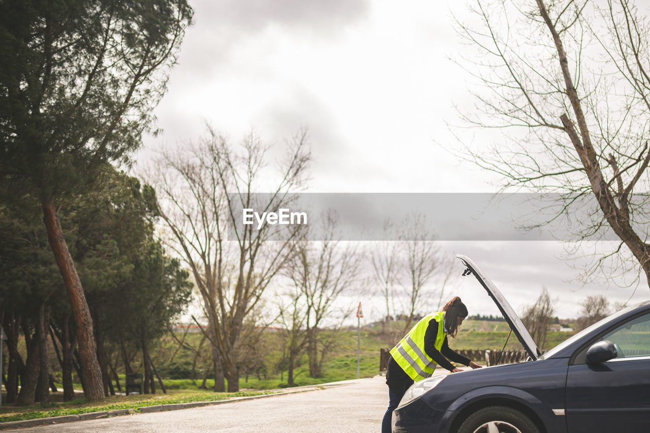 transportation, mode of transportation, tree, car, motor vehicle, road, driving, nature, sky, plant, vehicle, one person, wheel, land vehicle, day, travel, adult, men, cloud, outdoors, clothing, journey