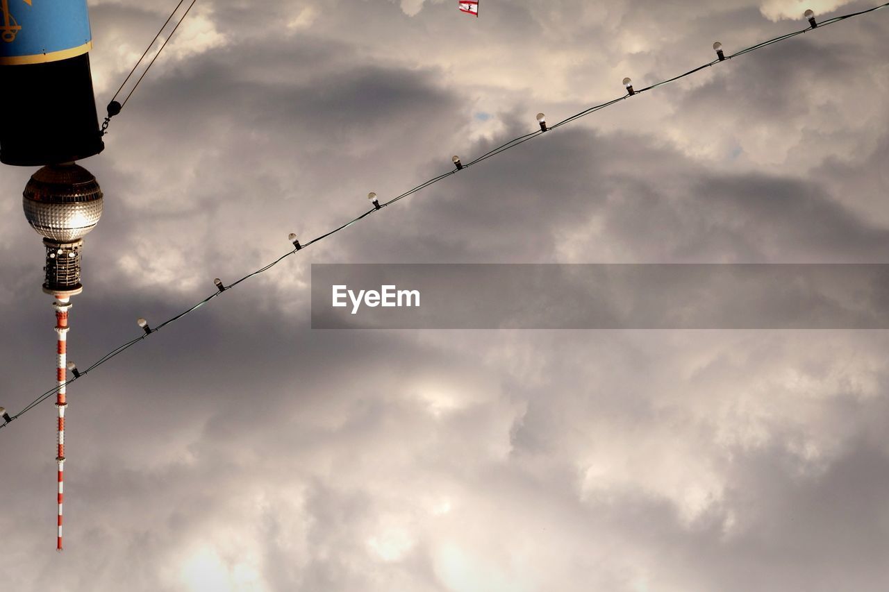 Upside down image of fernsehturm and christmas lights against storm clouds