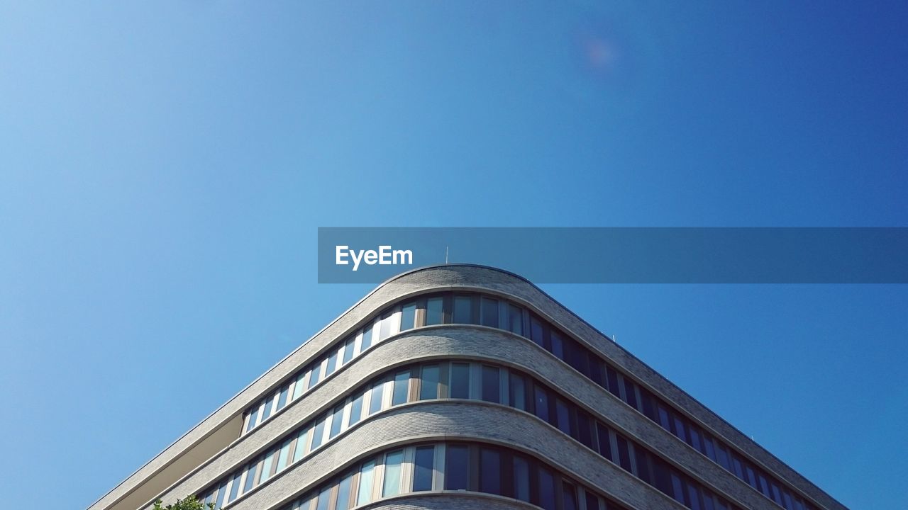 Low angle view of modern building against blue sky