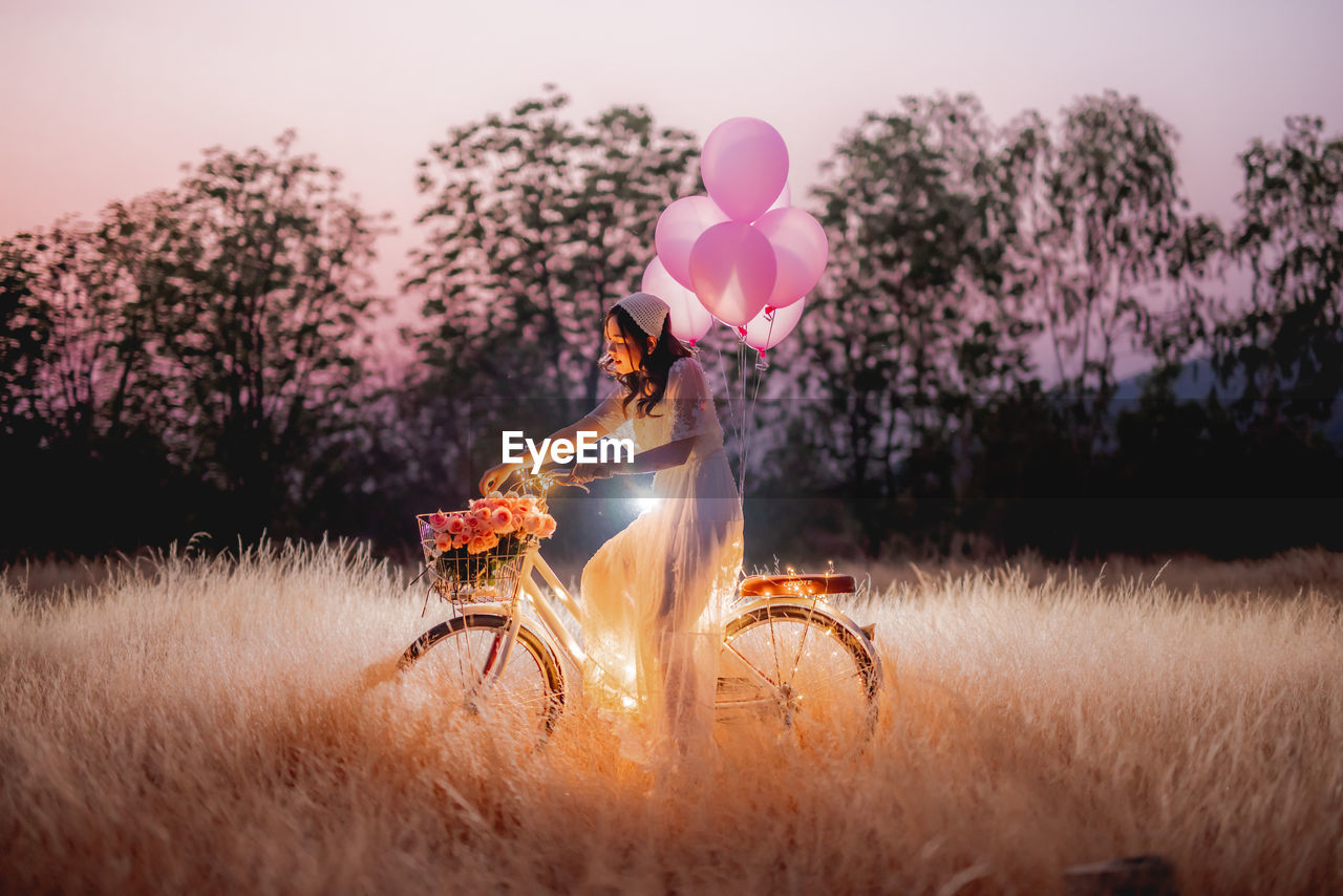 VIEW OF PERSON HOLDING BALLOON ON FIELD