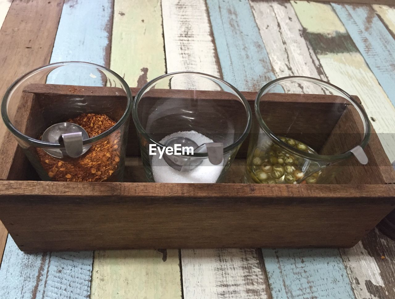 High angle view of spices in glass containers on table