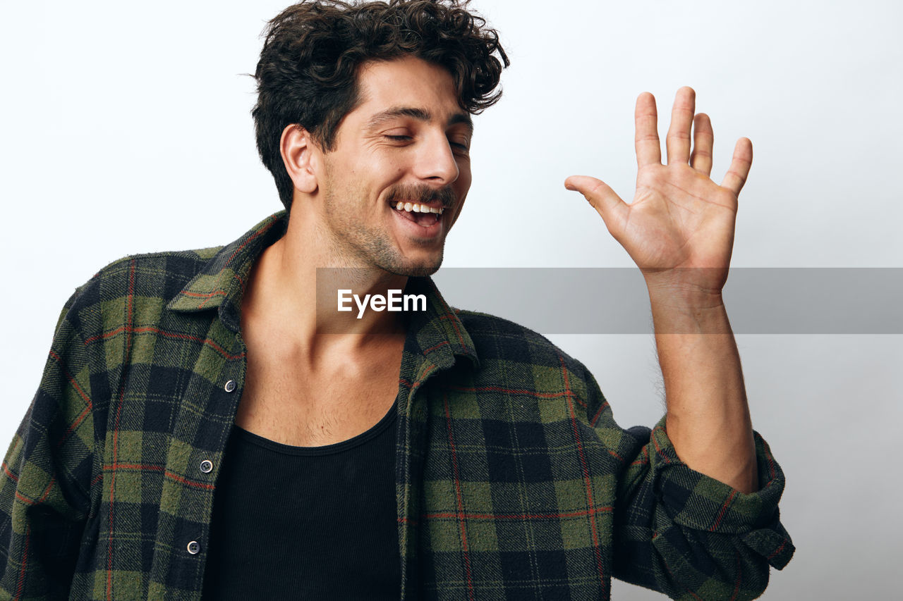 portrait of young man gesturing against white background