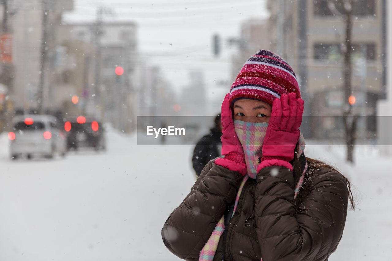 Portrait of woman in city during winter