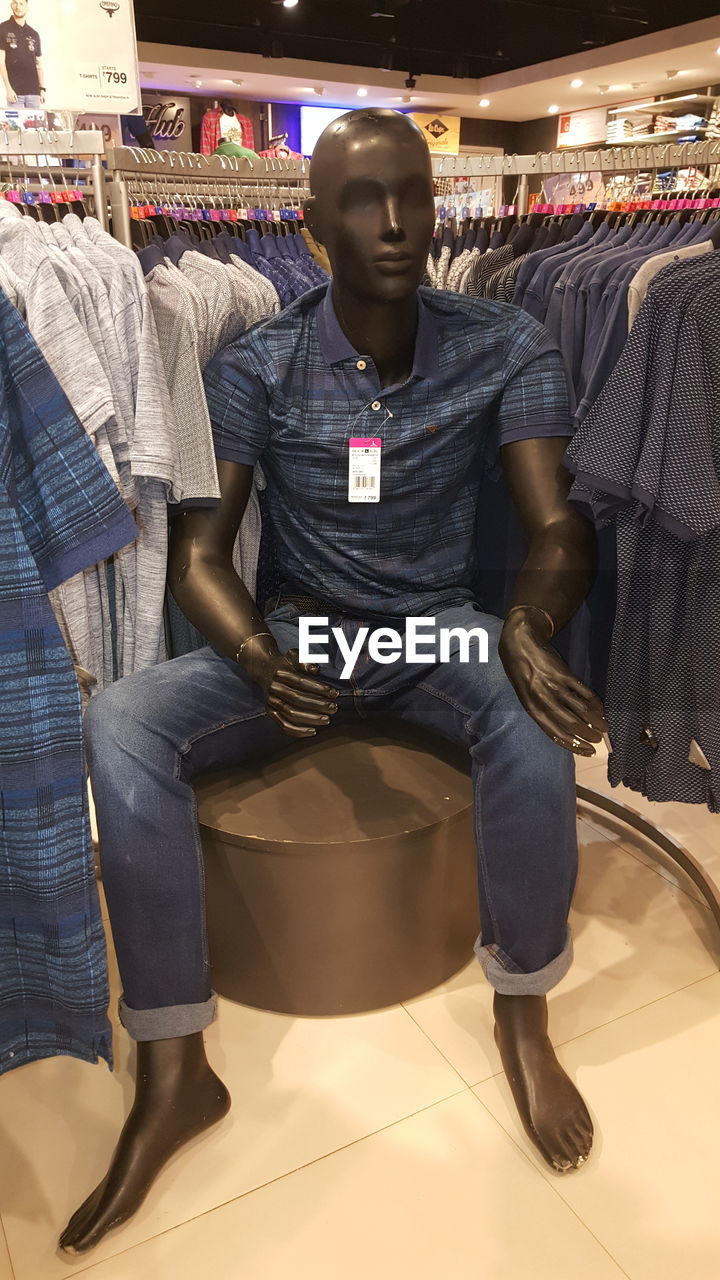 MAN SITTING IN STORE