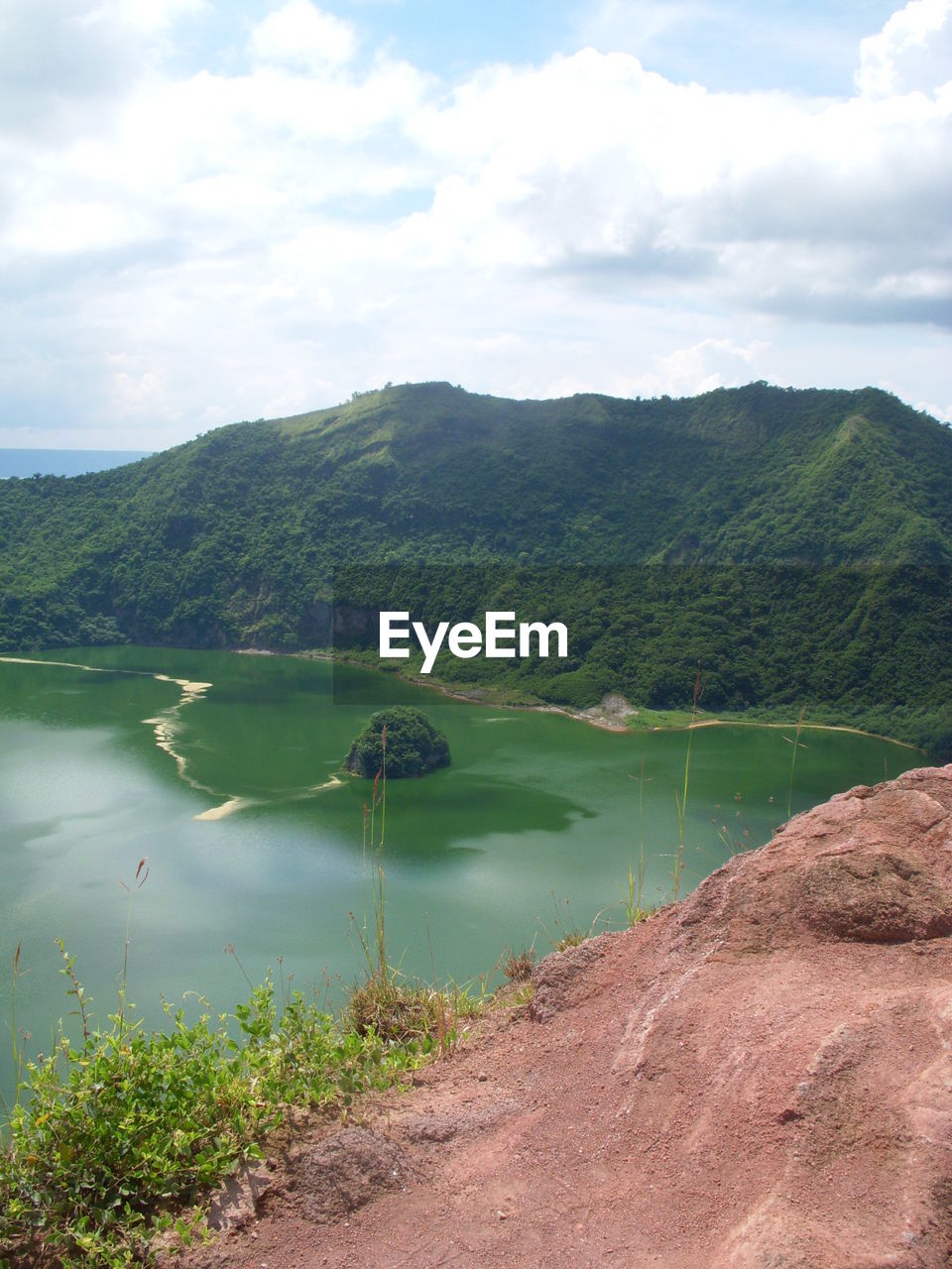 Scenic view of lake by mountains against sky