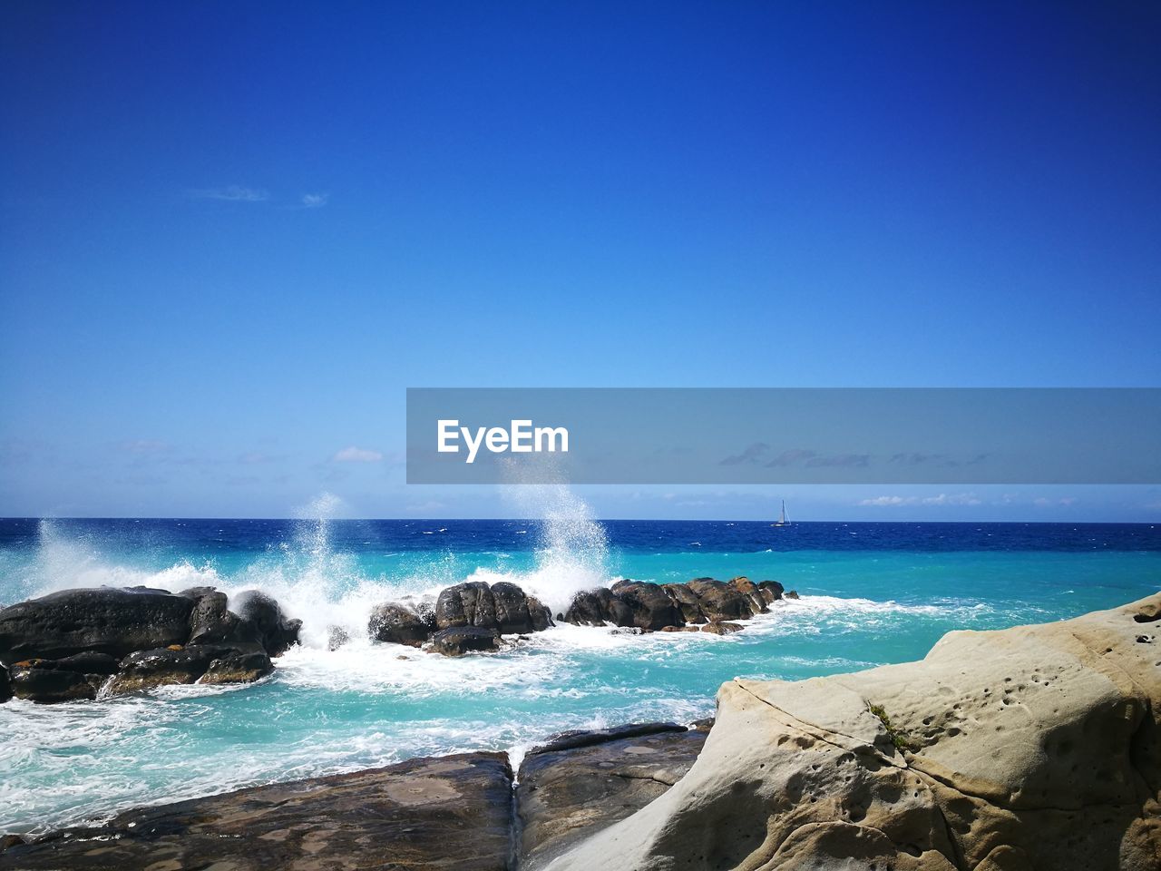 Scenic view of sea against clear blue sky