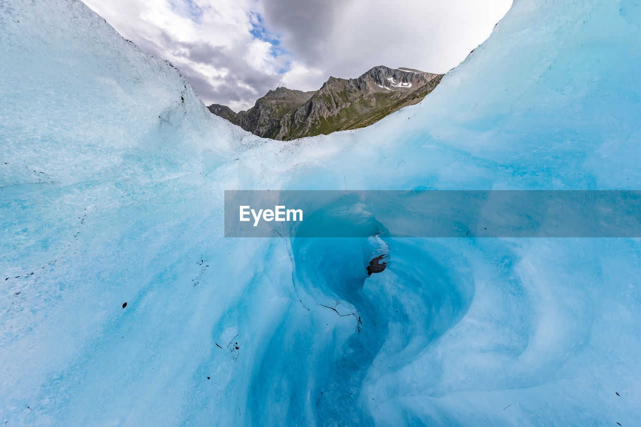 Low angle view of ice formation against cloudy sky