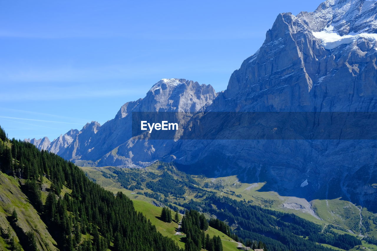 Panoramic view of snowcapped mountains against blue sky