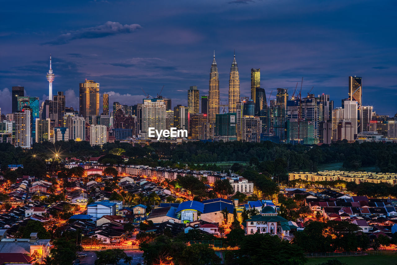 ILLUMINATED CITY BUILDINGS AGAINST SKY