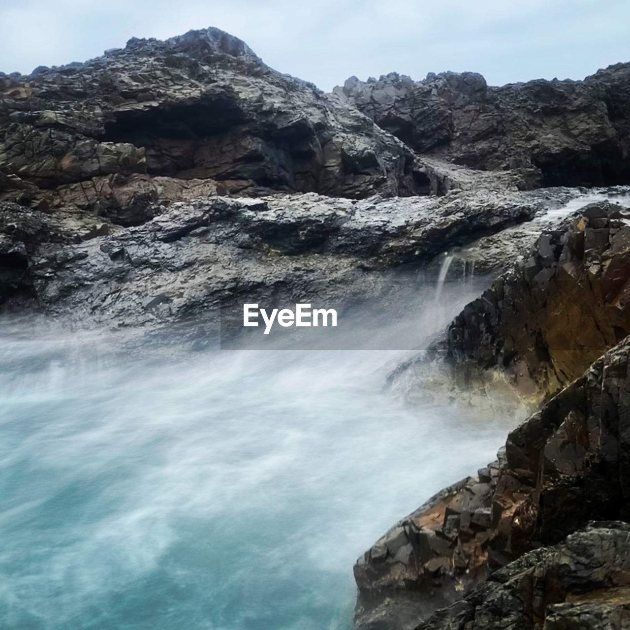 SCENIC VIEW OF ROCKS IN SEA AGAINST SKY