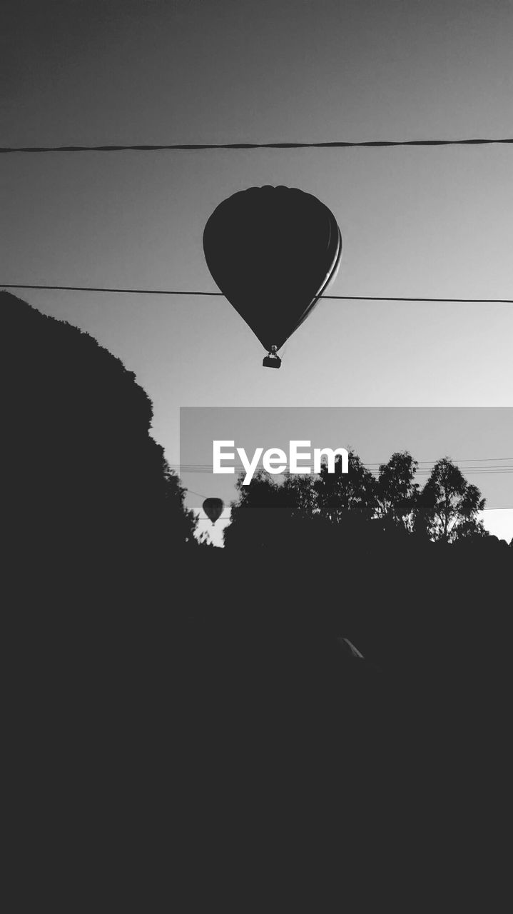 Low angle view of hot air balloons flying against sky