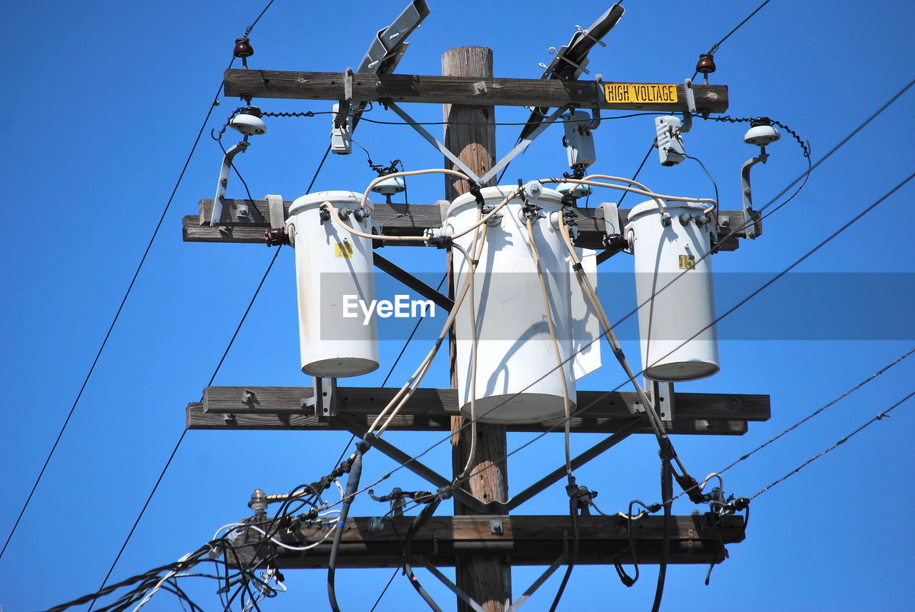 High voltage power lines high in the sky outdoors.