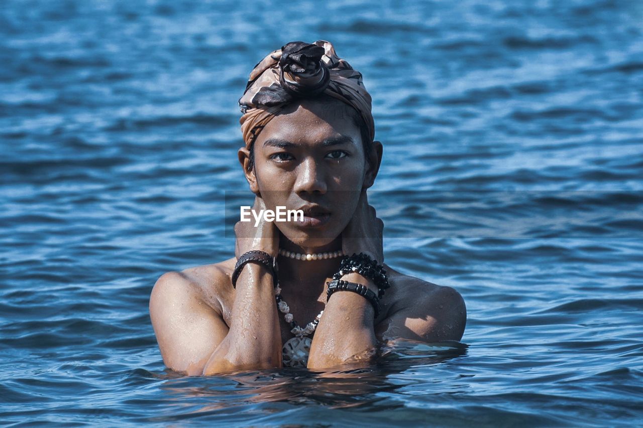 Portrait of young man swimming in lake