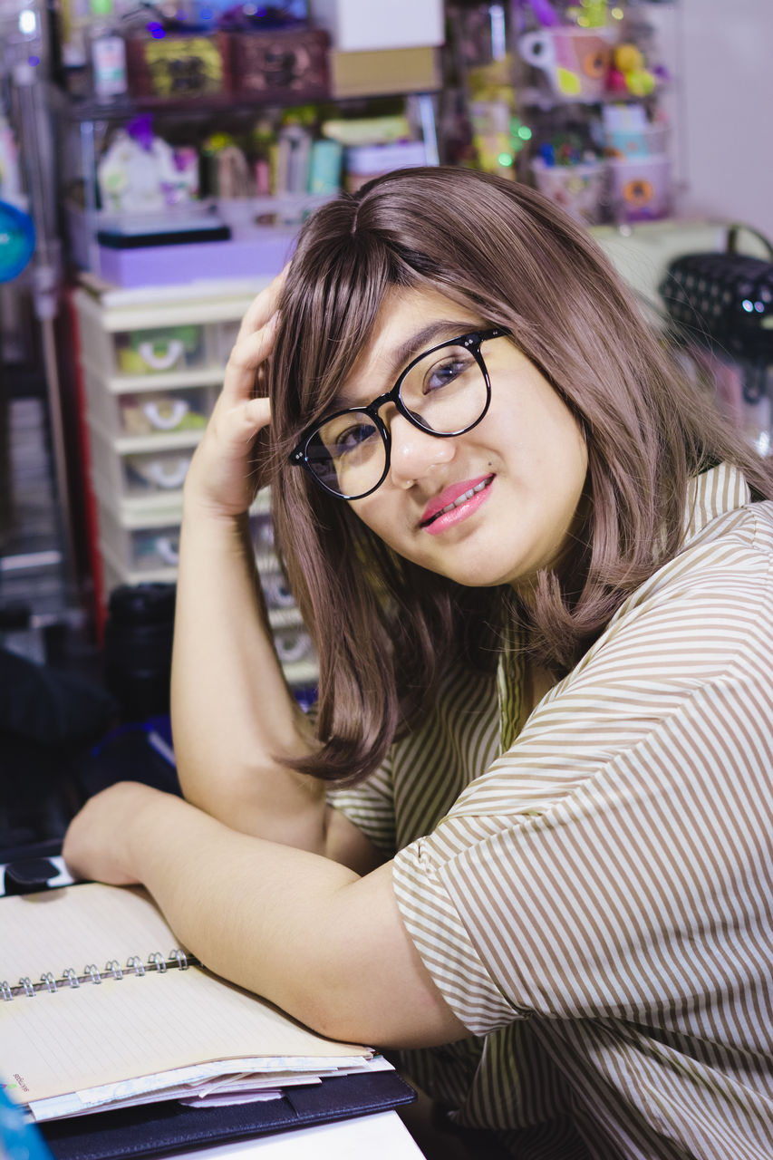 Portrait of a young girl sitting at desk with an open book