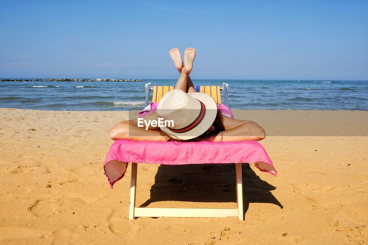 Woman sunbathing on the deck chair 