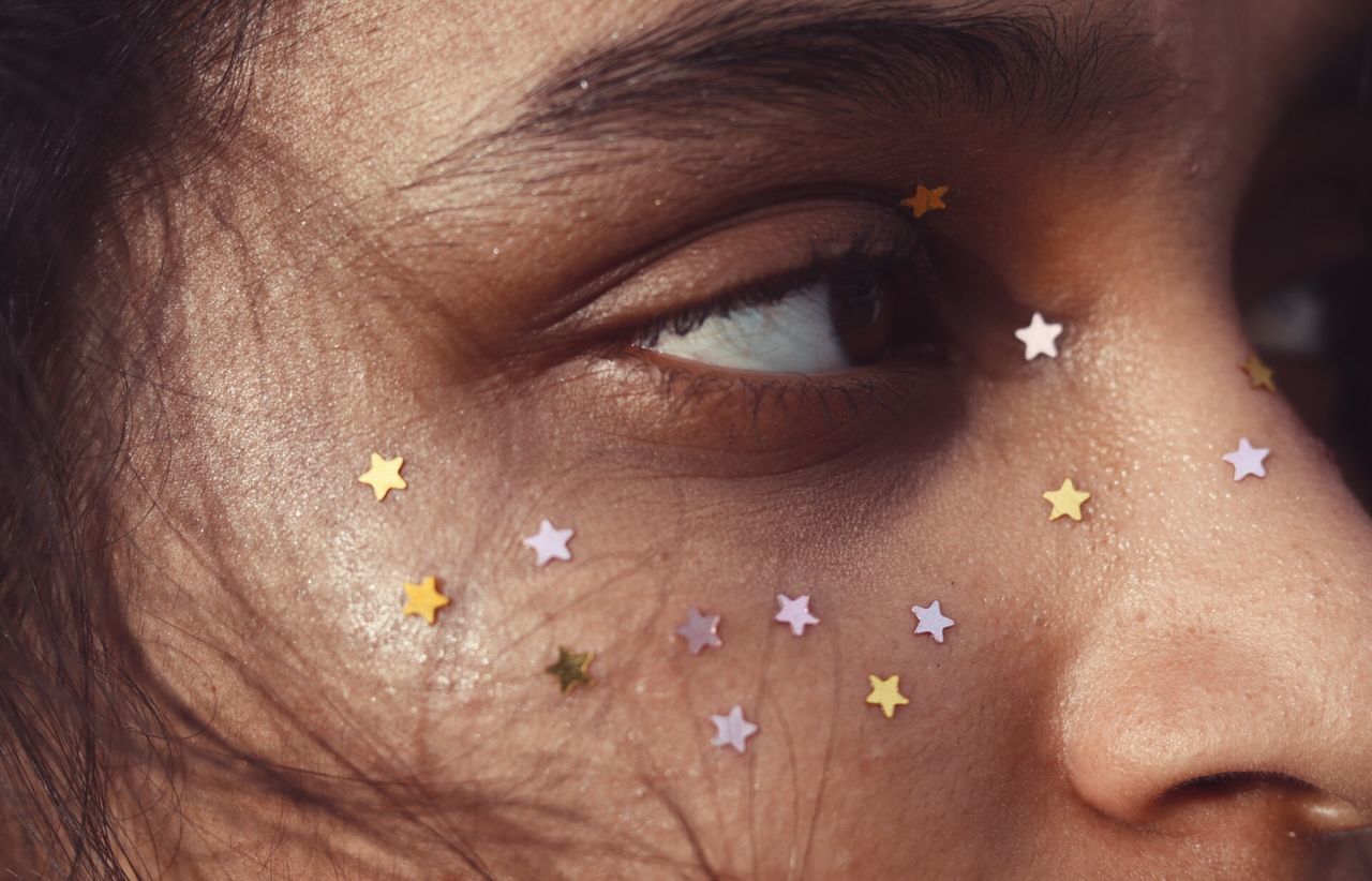 Close-up of woman with star shape decoration on face