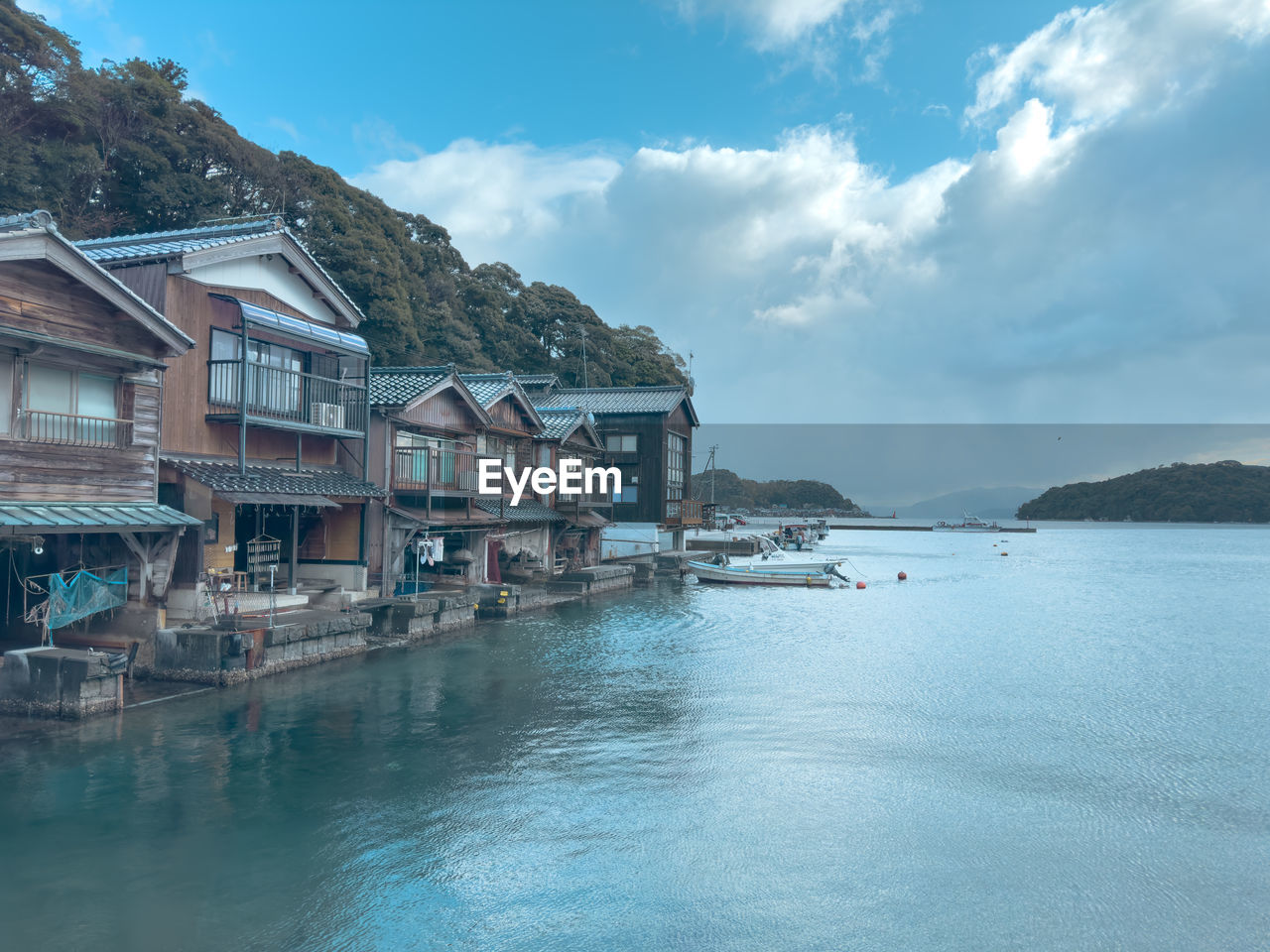 buildings by river against sky