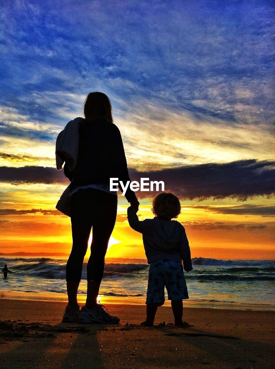 Rear view of mother and child on beach