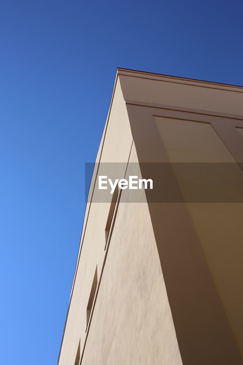 LOW ANGLE VIEW OF BUILDING AGAINST BLUE SKY